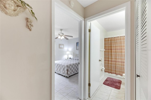 bathroom with a shower with shower curtain, tile patterned floors, toilet, and ceiling fan