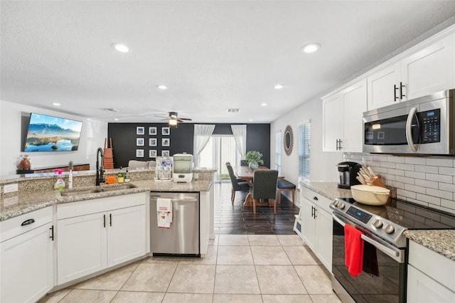 kitchen featuring appliances with stainless steel finishes, white cabinetry, ceiling fan, and sink