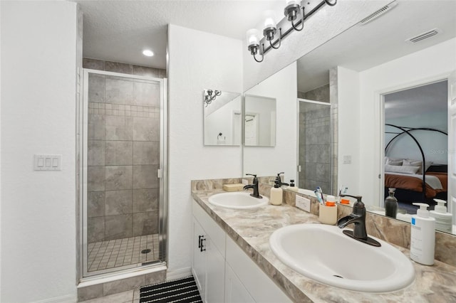 bathroom featuring tile patterned floors, vanity, a shower with shower door, and a textured ceiling