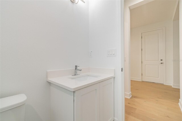 bathroom with vanity, toilet, and wood-type flooring