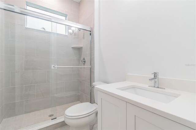 bathroom featuring vanity, toilet, and walk in shower