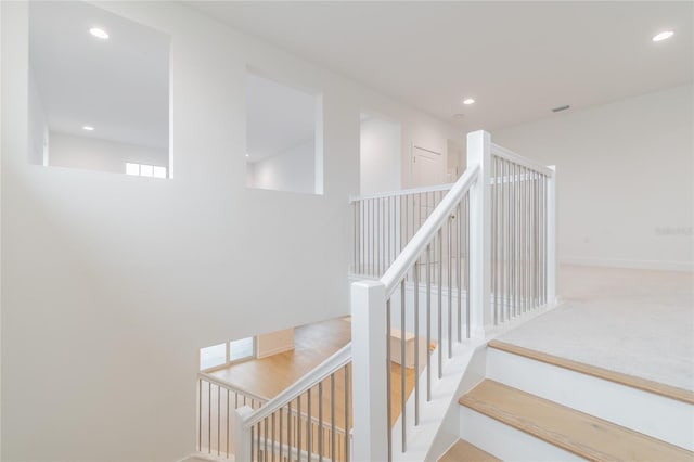 stairway featuring carpet flooring