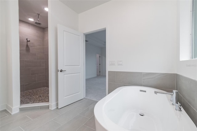 bathroom featuring tile patterned flooring, shower with separate bathtub, and tile walls