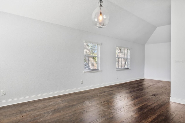 unfurnished room featuring dark wood-type flooring and vaulted ceiling