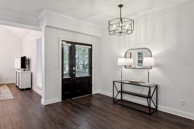 entryway with dark wood-type flooring, ornamental molding, and a notable chandelier