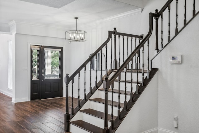 foyer featuring crown molding, dark hardwood / wood-style floors, and a chandelier