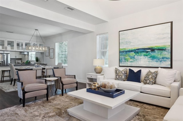 living room featuring ornamental molding, dark hardwood / wood-style floors, and a chandelier