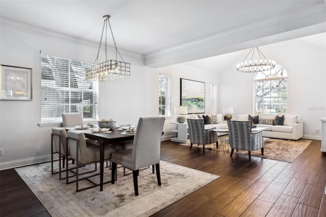 dining room with dark hardwood / wood-style flooring, a notable chandelier, plenty of natural light, and ornamental molding