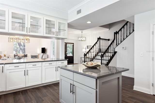 kitchen featuring white cabinetry, decorative light fixtures, dark wood-type flooring, and a center island