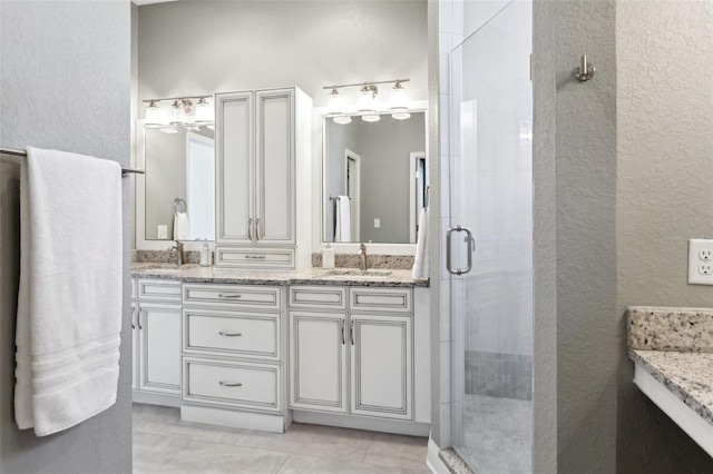 bathroom featuring vanity, tile patterned flooring, and a shower with shower door