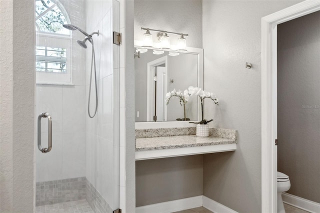 bathroom with an enclosed shower and toilet