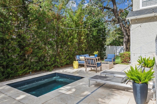 view of pool with a patio and an outdoor living space with a fire pit