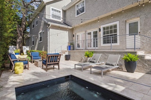 rear view of property featuring a patio area and outdoor lounge area