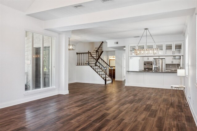 unfurnished living room with a notable chandelier and dark wood-type flooring