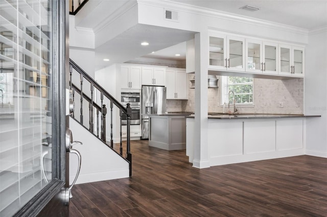 kitchen with crown molding, dark wood-type flooring, white cabinetry, stainless steel fridge with ice dispenser, and kitchen peninsula