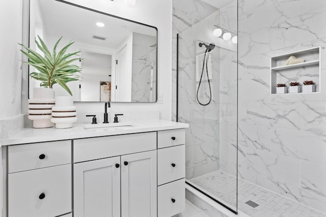 bathroom featuring a tile shower and vanity