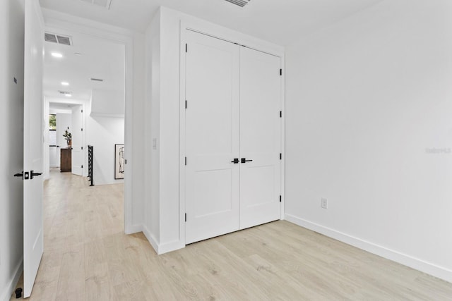 unfurnished bedroom featuring light hardwood / wood-style floors and a closet