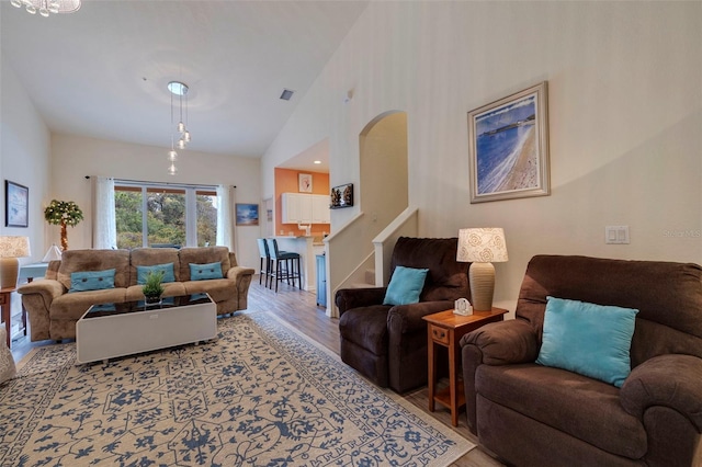 living room with high vaulted ceiling and hardwood / wood-style flooring