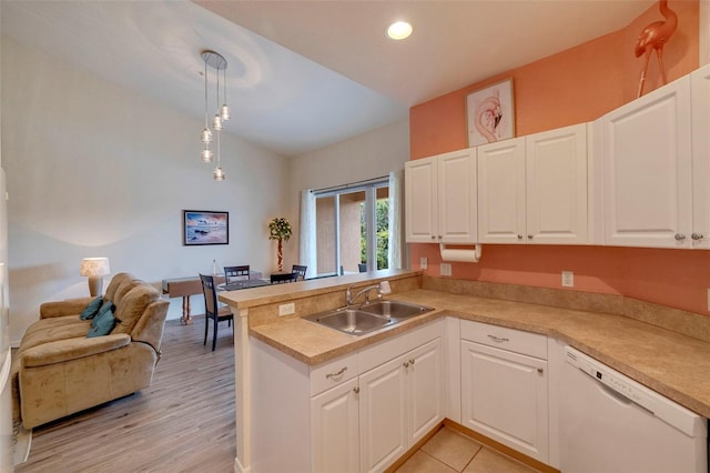 kitchen featuring white dishwasher, sink, hanging light fixtures, light hardwood / wood-style floors, and kitchen peninsula