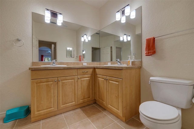 bathroom featuring tile patterned flooring, vanity, and toilet