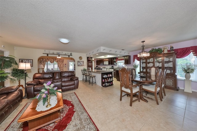 living room featuring a notable chandelier and a textured ceiling