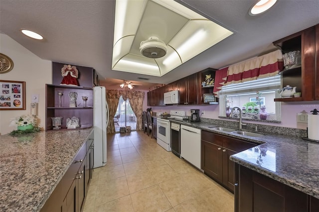 kitchen with white appliances, sink, ceiling fan, dark stone countertops, and light tile patterned flooring