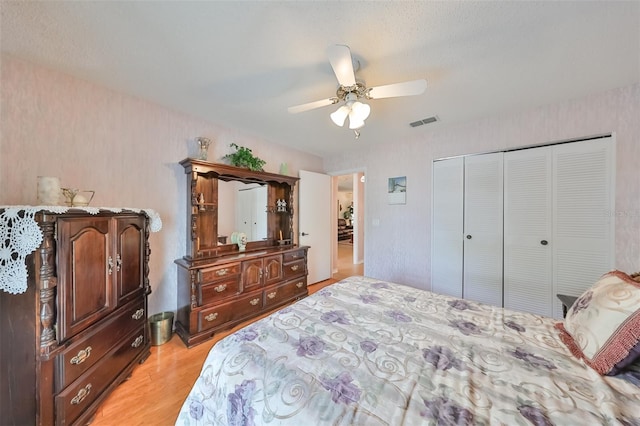 bedroom with a closet, ceiling fan, and light hardwood / wood-style flooring