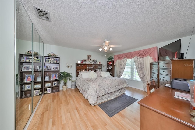 bedroom featuring a textured ceiling, hardwood / wood-style flooring, and ceiling fan