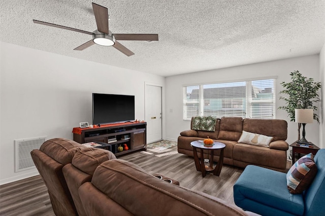 living room featuring ceiling fan, a textured ceiling, visible vents, and wood finished floors