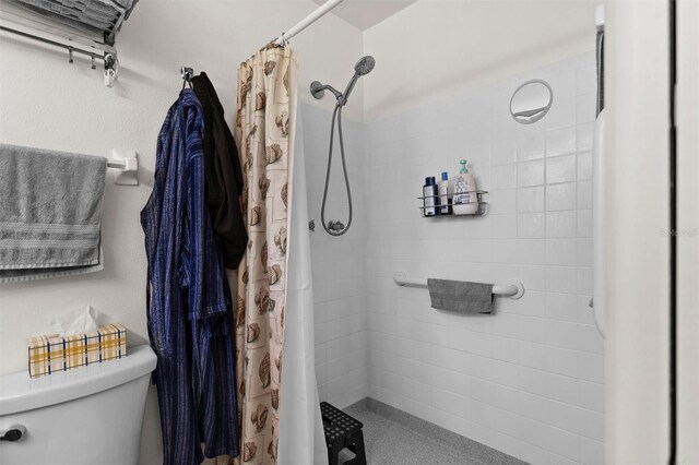 full bath featuring a tile shower and toilet