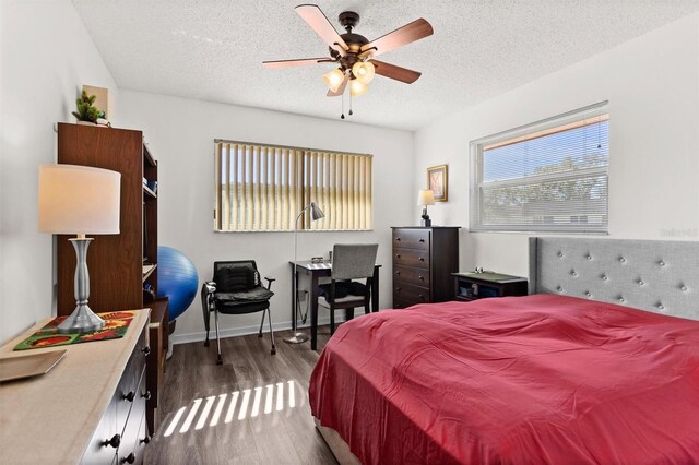 bedroom with a ceiling fan, a textured ceiling, baseboards, and dark wood-type flooring