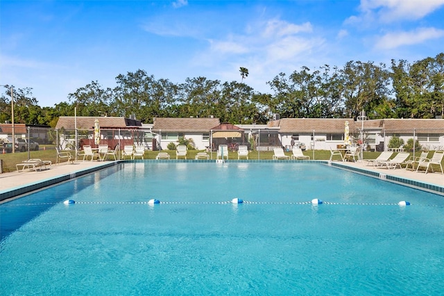 pool with a patio and fence