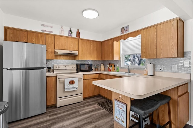 kitchen with black microwave, extractor fan, a sink, freestanding refrigerator, and white electric range oven