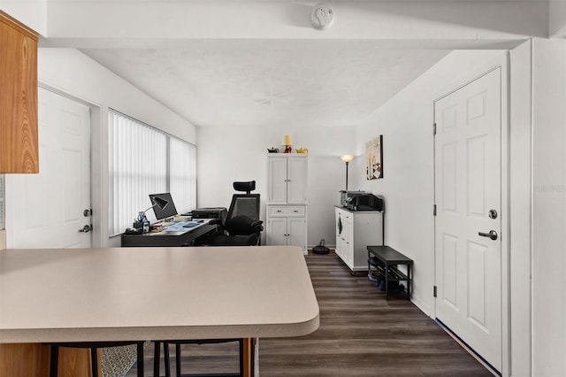 home office with dark wood-type flooring and baseboards