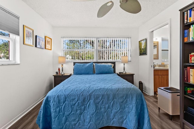 bedroom with dark wood-style floors, multiple windows, and a textured ceiling