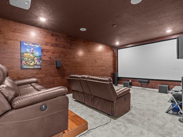 home theater room featuring carpet floors, a textured ceiling, and wooden walls