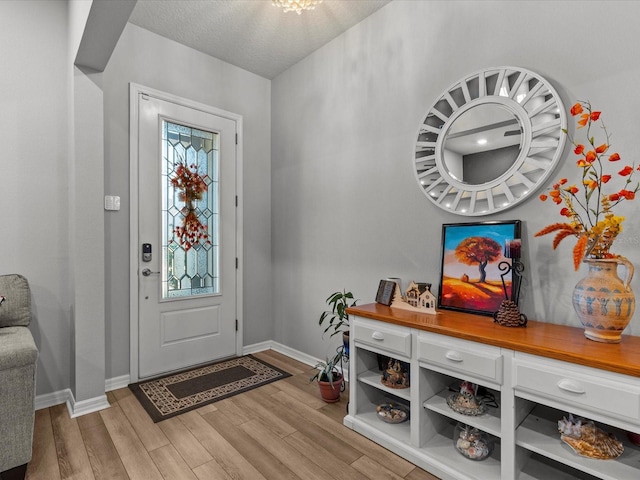 entrance foyer with a textured ceiling and light wood-type flooring