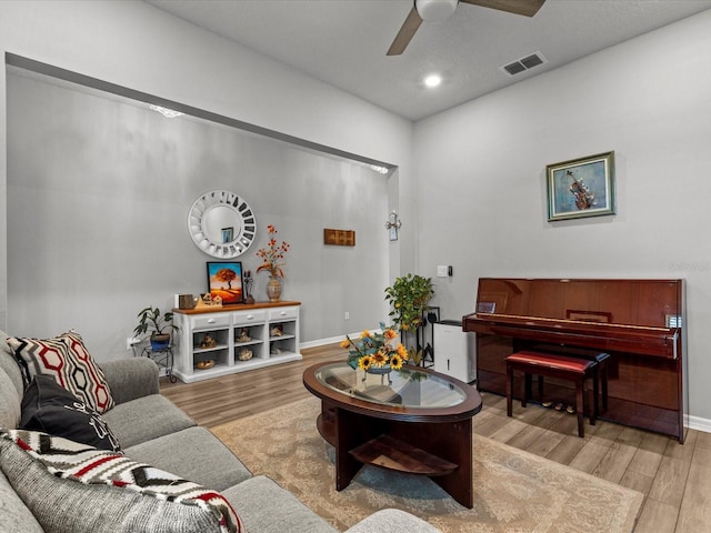 living room featuring light hardwood / wood-style flooring and ceiling fan