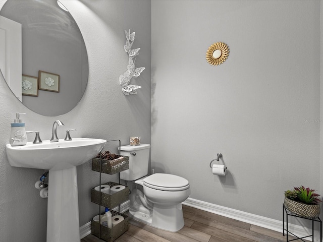 bathroom featuring wood-type flooring and toilet