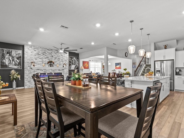 dining space featuring ceiling fan, light hardwood / wood-style flooring, and sink