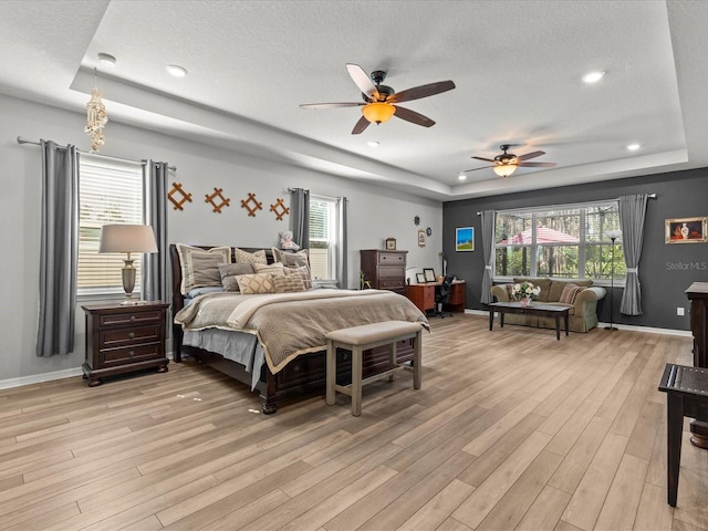 bedroom featuring ceiling fan, light hardwood / wood-style floors, and a textured ceiling