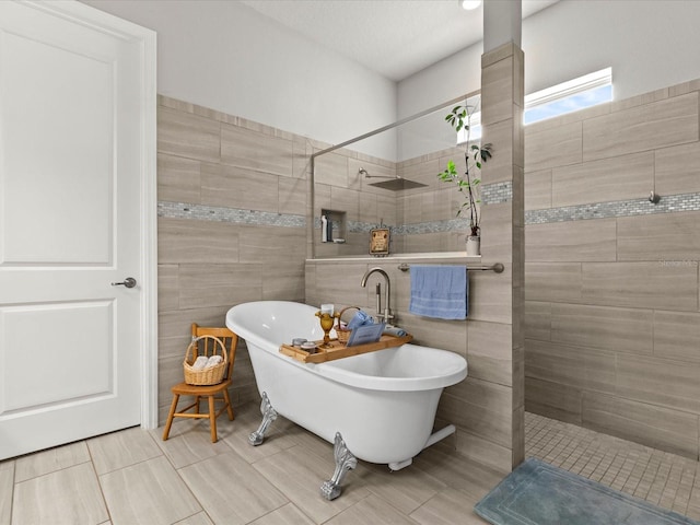 bathroom with shower with separate bathtub and tile walls