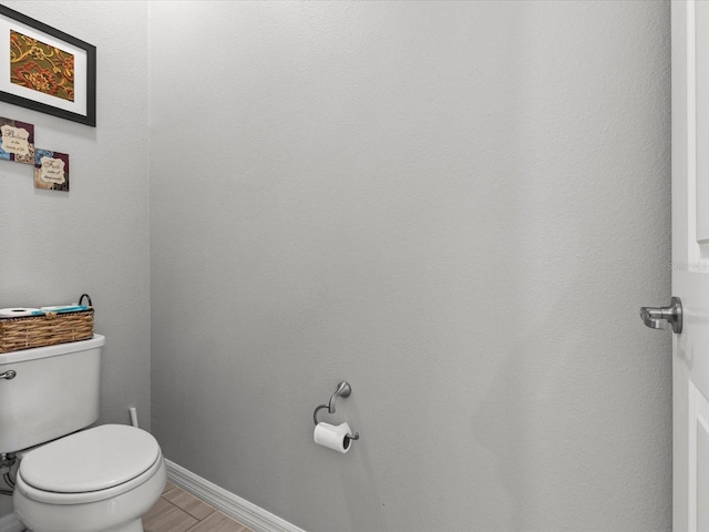 bathroom featuring wood-type flooring and toilet