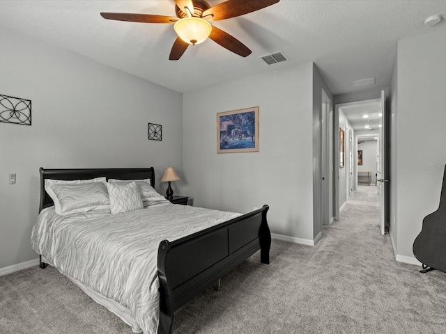 carpeted bedroom featuring ceiling fan and a textured ceiling