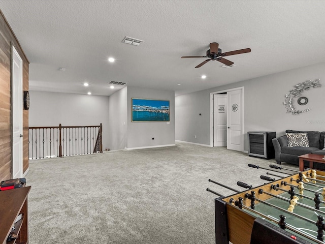 game room featuring ceiling fan, carpet floors, and a textured ceiling