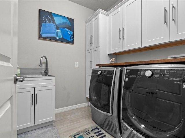 laundry area featuring cabinets, separate washer and dryer, and light wood-type flooring