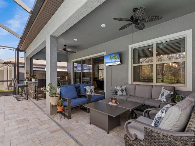 view of patio / terrace with a lanai, an outdoor living space, and ceiling fan