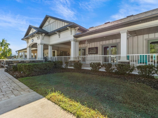 view of side of property with covered porch and a lawn