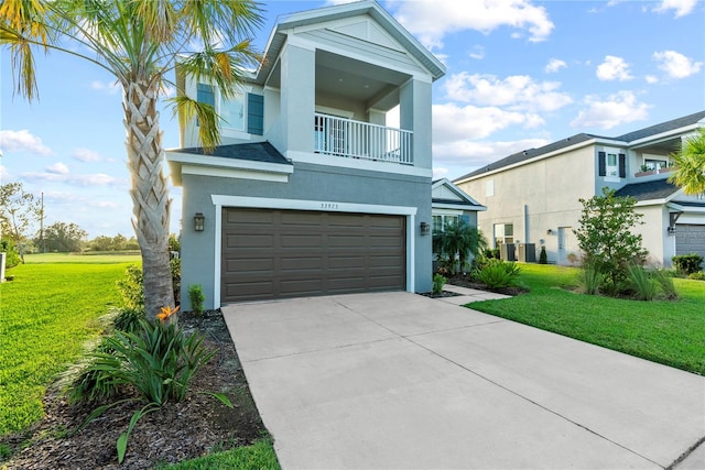 view of front facade featuring a front yard, a balcony, and a garage