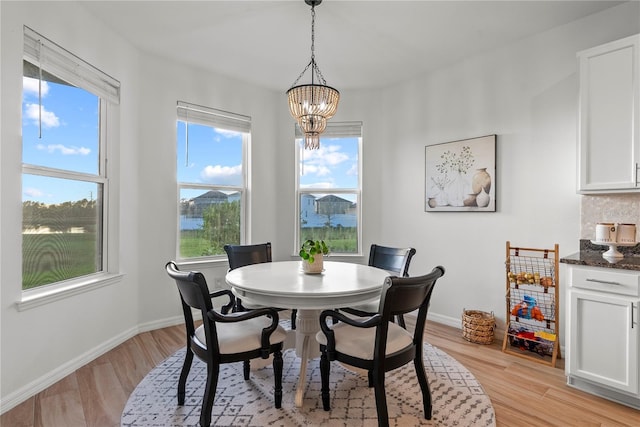 dining space featuring a notable chandelier and light wood-type flooring